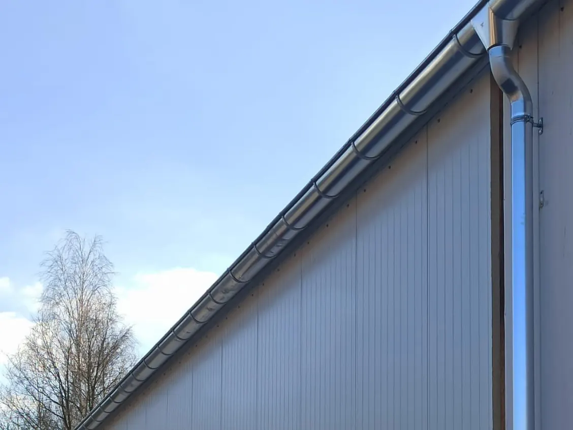 Dachrinne und Fallrohr an einer Hallenfassade – Klempnerarbeiten